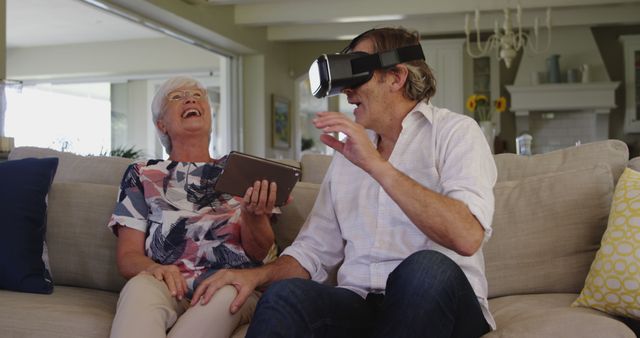 Elderly Couple Laughing and Using Virtual Reality Goggles on Sofa - Download Free Stock Images Pikwizard.com