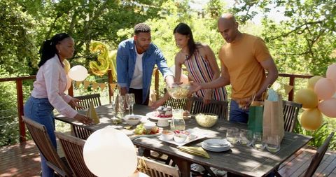 Friends Setting Table for Outdoor Birthday Celebration