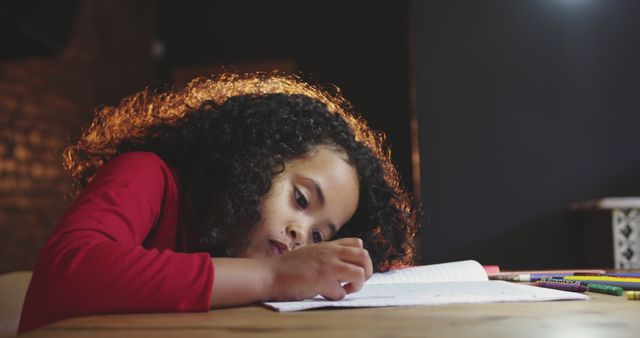 Focused Child Writing in Notebook with Colored Pencils on Table - Download Free Stock Images Pikwizard.com