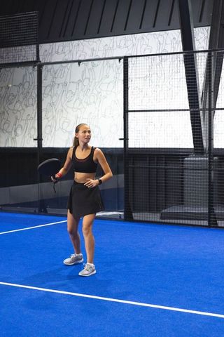 Asian Female Athlete Padel Tennis Action on Blue Turf Court