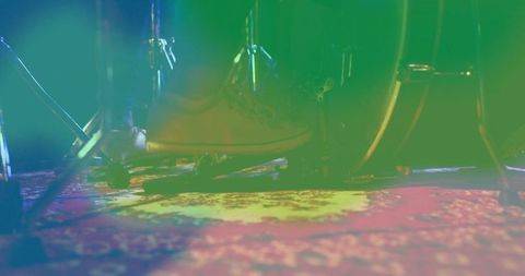 Musician pressing drum pedal in artistic lighting