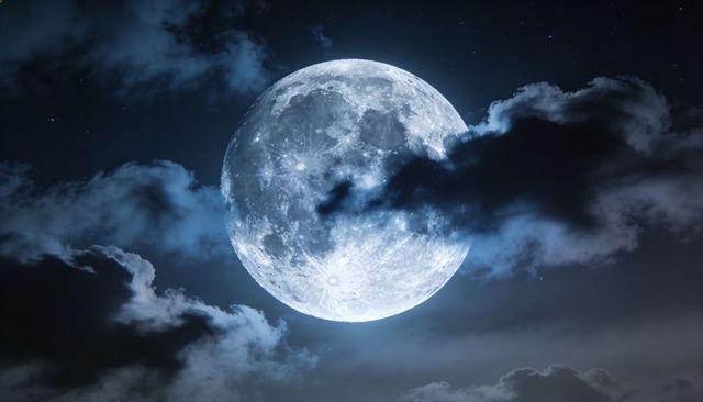 Shining Full Moon Revealing Crater Detail with Layered Clouds and Starry Night Sky