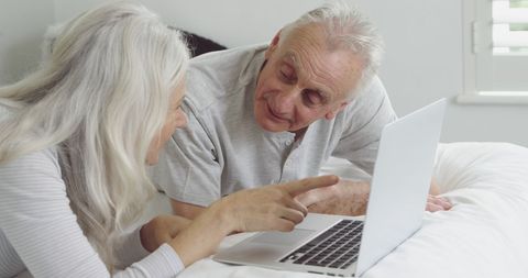 Senior Couple Engaging with Technology at Home, Sharing Joy