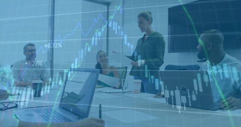 Presenting team analyzing financial charts with stock market overlay in modern boardroom