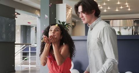 Diverse Couple Joyfully Celebrating with Confetti Indoors