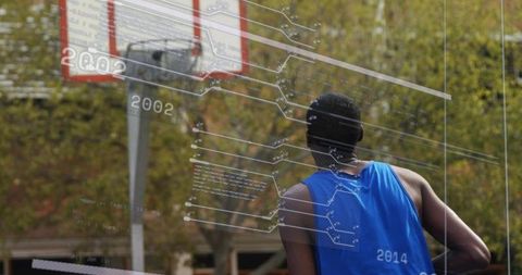 Athlete watching basketball hoop on outdoor court with digital analytics overlay