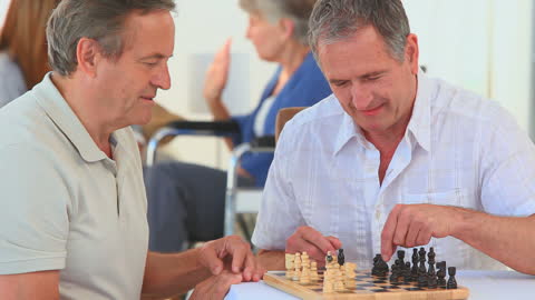 Senior Friends Engaging in Chess Game at Retirement Home