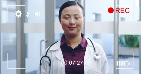 Young asian female doctor smiling during digital recording
