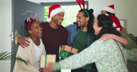 Diverse Friends Embracing and Exchanging Gifts at Holiday Gathering