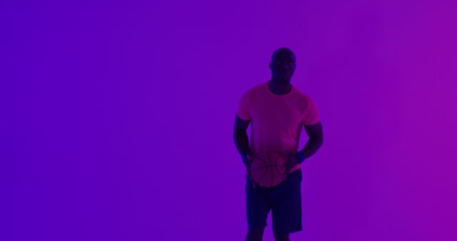 Image of african american male basketball player throwing ball on purple background. Sports and competition concept.