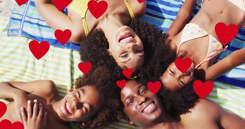 Joyful Family Lying on Beach Towels with Heart Graphics