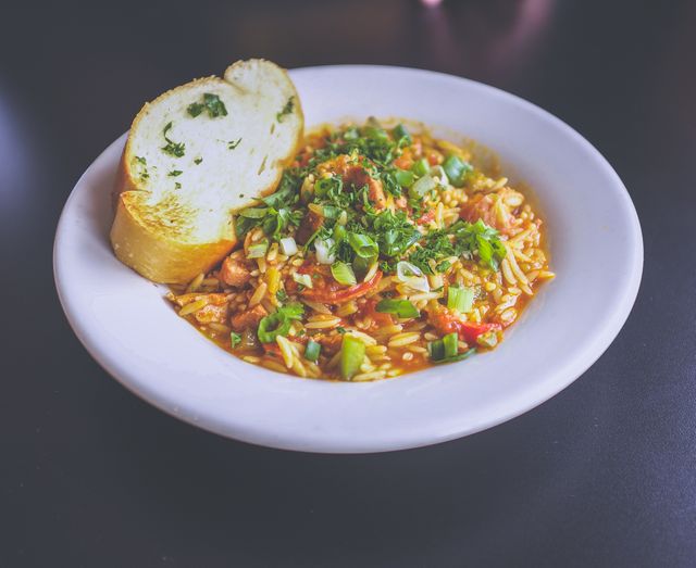 Featuring a hearty lentil soup with green onions and served with slices of garlic bread, perfect for articles on Healthy Eating, Vegetarian Recipes, Winter Comfort Foods. Could be used by food bloggers, nutritionists, or for culinary magazine covers advertising vegetarian meals.