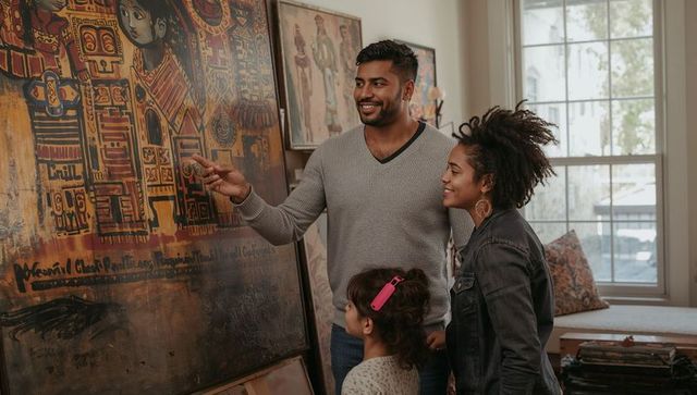 Family exploring vibrant abstract painting in cozy home studio father guiding child
