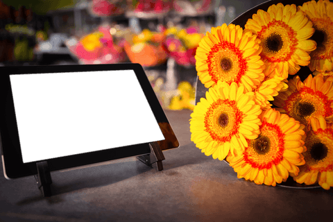 Transparent digital tablet with bright yellow flowers displayed