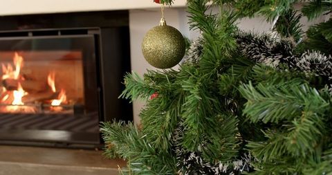 Cozy Christmas Tree with Gold Ornament by Fireplace