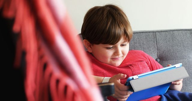 Young Boy Enjoying Tablet at Home on Couch - Download Free Stock Images Pikwizard.com