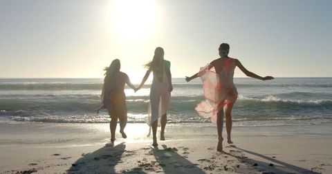 Carefree Women Holding Hands at the Beach in Slow Motion - Download Free Stock Images Pikwizard.com