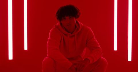 Urban fashion mood in red lit studio with vibrant neon lighting