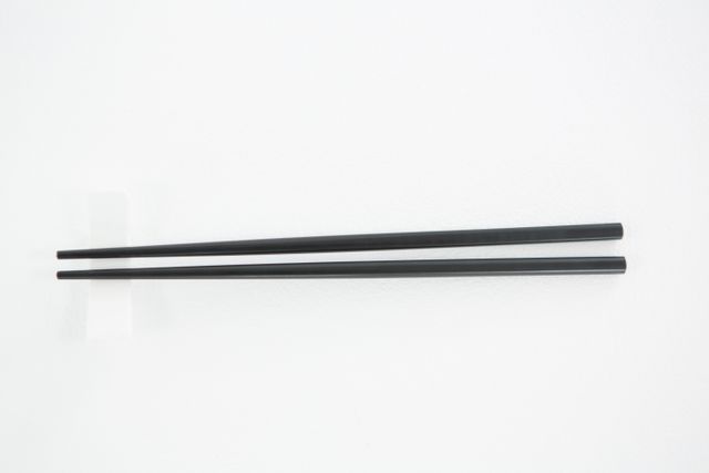Chopsticks on a chopstick rest against white background