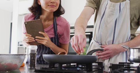 Happy Couple Cooking Together Using Tablet