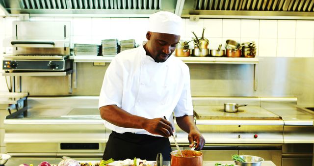 This image captures a chef preparing a delicious meal in a modern restaurant kitchen. It is ideal for promoting culinary schools, professional cooking courses, restaurant advertisements, kitchen equipment suppliers, food blogs, and hospitality industry magazines. It highlights a professional environment, culinary skills, and the essence of fine dining preparation.