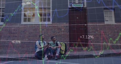 Young men sitting on urban curb viewing stock market overlay with backpacks and headphones