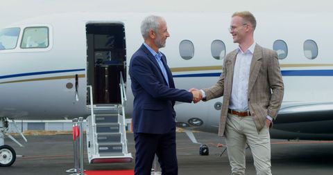 Businessmen Handshaking Beside Private Jet on Runway - Download Free Stock Images Pikwizard.com