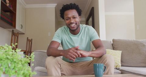 Smiling Man Relaxing on Sofa with Cup at Home