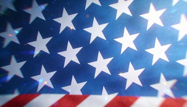 Close-up american flag canton showing white stars and red stripes with lens flares