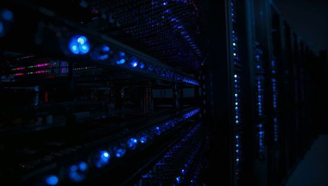 Glowing blue server racks emitting led arrays along data center aisle for tech design