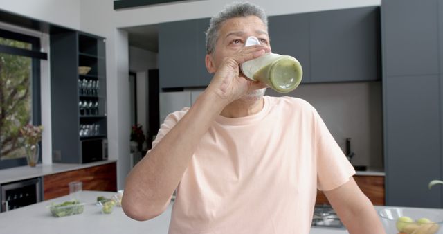 Healthy Middle-Aged Man Drinking Green Smoothie in Modern Kitchen - Download Free Stock Images Pikwizard.com