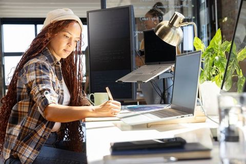 Productive african american woman working at modern office desk