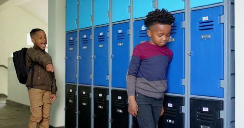 Diverse boys opening school lockers belongings reorganization breaktime