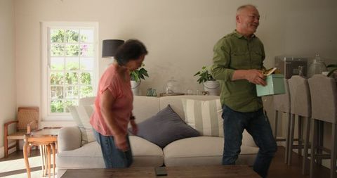 Senior couple celebrating at home with gift box