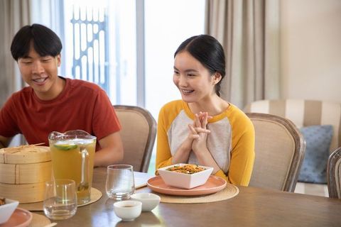 Asian Couple Enjoying Meal with Noodle Salad and Iced Tea