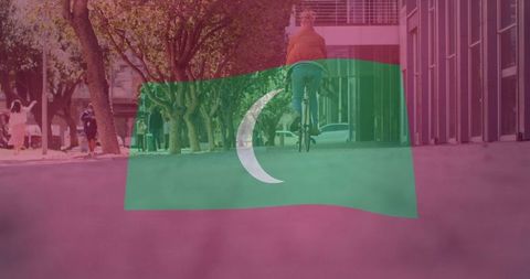 Cyclist Riding Along Urban Pathway with Flag Overlay