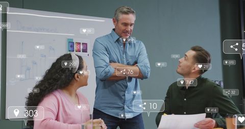 Colleagues interact and discuss concept visualizations in an office, with social media notification icons floating around them, symbolizing the integration of digital technology in work processes. This could be used to illustrate concepts of digital collaboration, remote work innovations, modern business practices, or the impact of social media on professional environments.