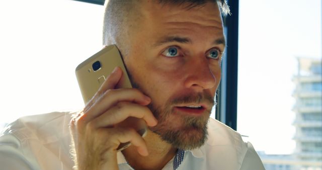 A middle-aged Caucasian businessman is engaged in a phone conversation, with copy space - Download Free Stock Photos Pikwizard.com