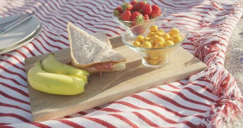 Relaxing Beach Picnic with Fresh Fruit and Sandwich