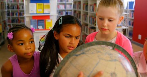 Curious Children Exploring Globe in School Library