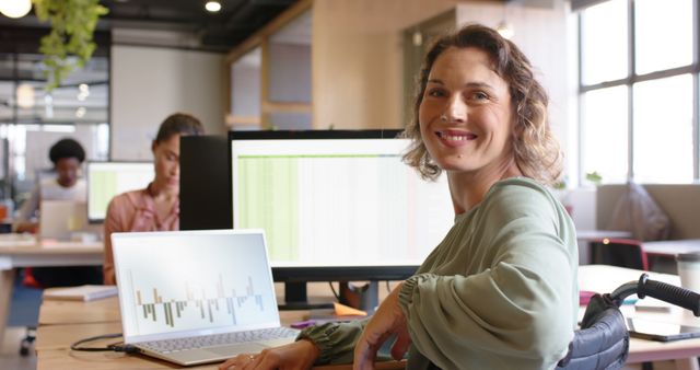 Portrait of happy caucasian casual businesswoman in wheelchair using laptop and computer in office - Download Free Stock Photos Pikwizard.com