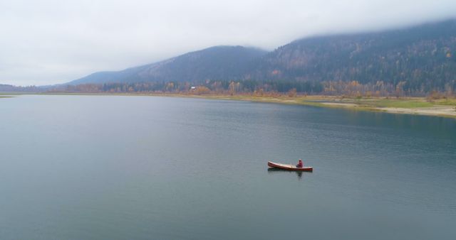 Solitary Canoe on Peaceful Lake with Foggy Mountains - Download Free Stock Images Pikwizard.com