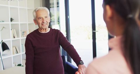Senior Man Interacts with Young Woman in Home Setting