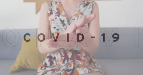 Woman sanitizing hands in office for covid-19 protection