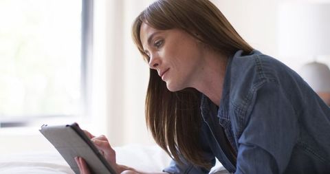 Middle-Aged Woman Using Tablet Relaxed At Home