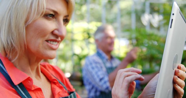 Older woman using digital tablet in garden center - Download Free Stock Images Pikwizard.com