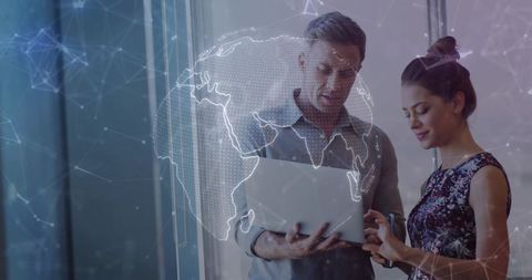 Professionals collaborating over laptop with holographic globe and network visualization