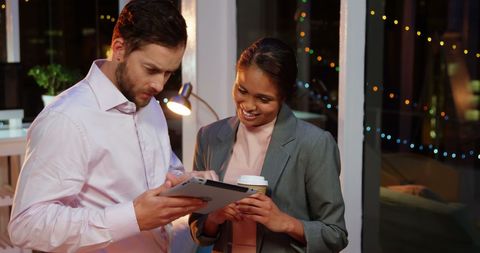 Diverse Professionals Collaborating on Project Late at Night