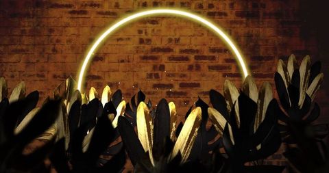 Vibrant Neon Circle Amidst Leaves on Brick Wall Background