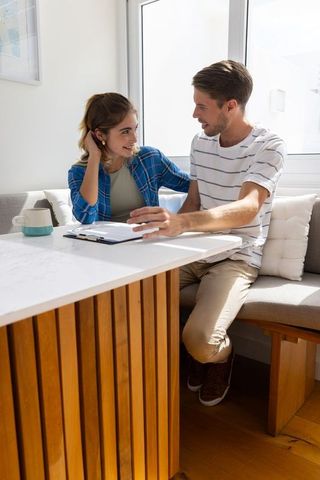 Couple Reviewing Document at Home in Cozy Dining Nook
